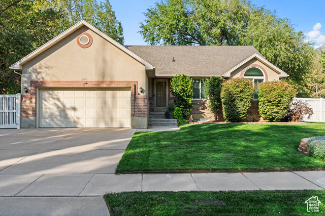 View of front of house with a garage and a front lawn