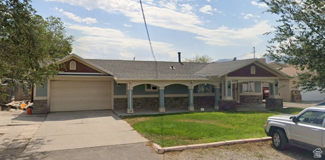 View of front of home featuring a front yard and a garage