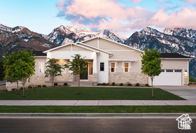 View of front of property featuring a mountain view, a garage, and a front lawn