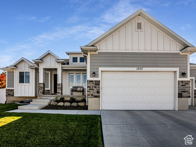 View of front facade featuring a front yard and a garage