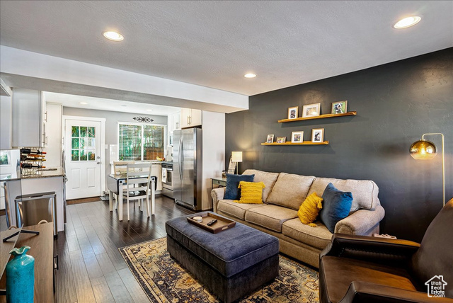 Living room with a textured ceiling and dark hardwood / wood-style floors