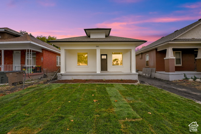 View of front of house featuring a yard and a porch