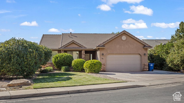 View of front of property with a front yard and a garage