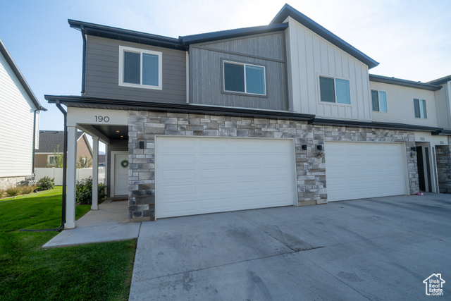 View of front of property featuring a front lawn and a garage