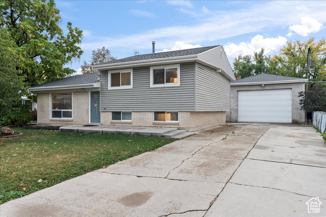 Tri-level home with a garage and a front lawn