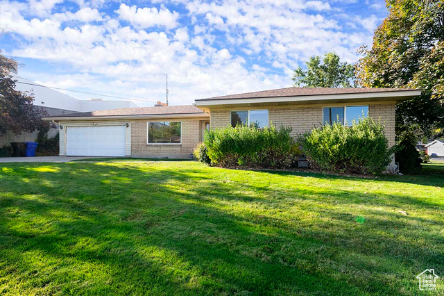 Single story home featuring a front lawn and a garage