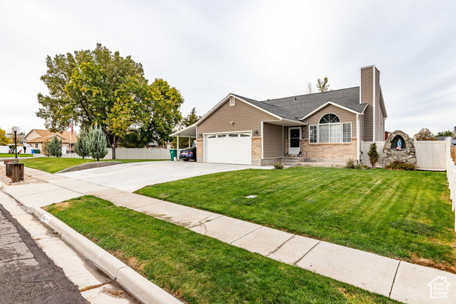 Ranch-style house featuring a garage and a front lawn