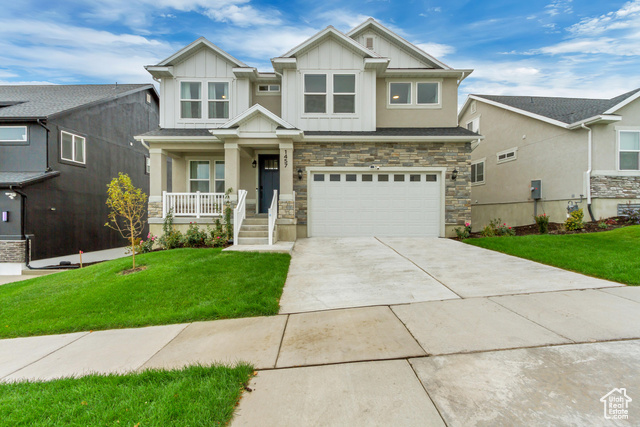 Traditional Elevation house with a porch, a front lawn, and a garage