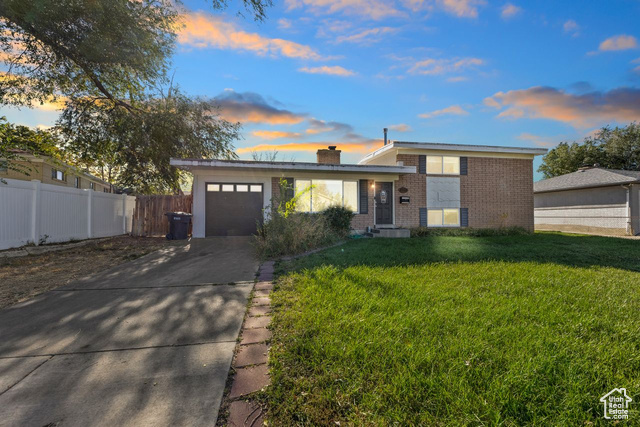 View of front of home featuring a yard and a garage