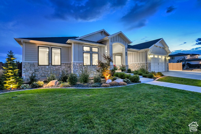 View of front facade featuring a garage and a lawn