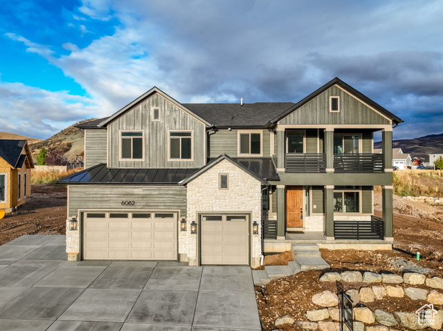 View of front facade featuring a mountain view, a garage, and a balcony