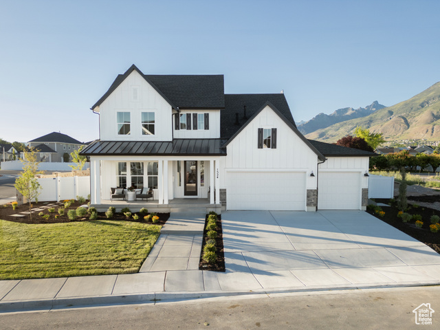 Exterior photos are of a previous home. Modern farmhouse style home with a porch, a front lawn, and a garage