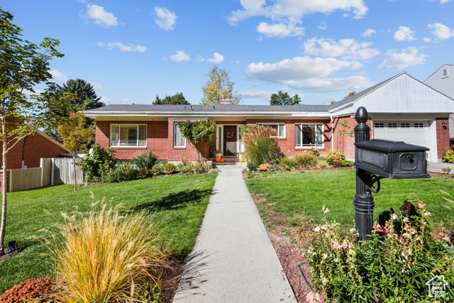 Ranch-style home with a garage and a front lawn