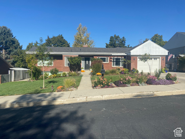 View of front of house with a front yard and a garage