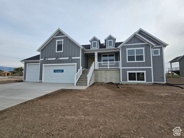 View of front of house with covered porch and a garage