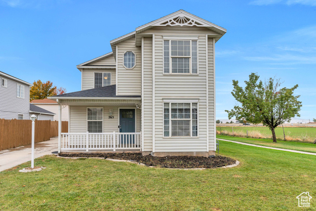 Front of property with covered porch and a front lawn