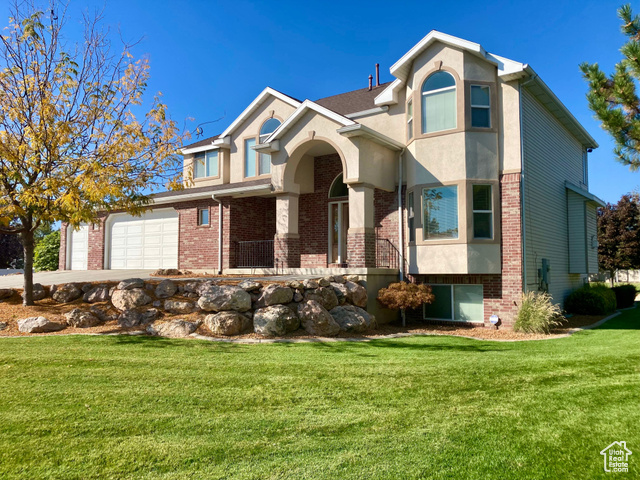 View of front of house with a garage and a front lawn