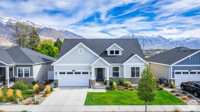 Craftsman inspired home featuring a front yard, a garage, and a mountain view