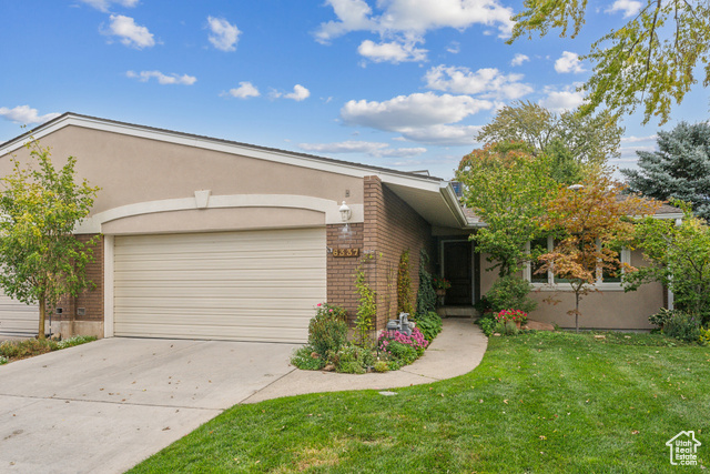 View of front of property with a front lawn and a garage