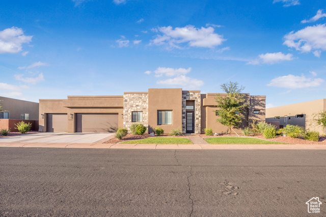 Pueblo-style home featuring a garage