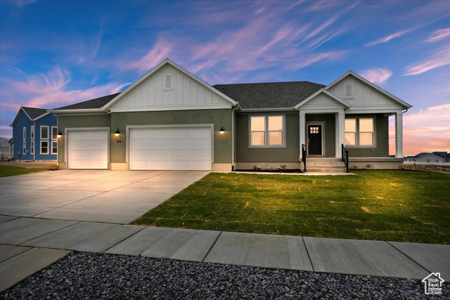 View of front of property featuring a yard and a 3 car garage