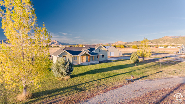 View of front of house with a mountain view and a front lawn