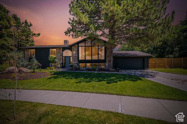 View of front of house featuring a yard and a garage