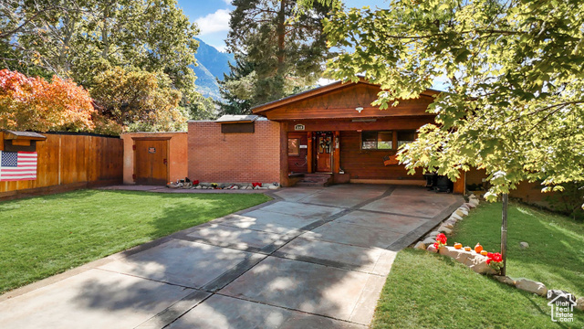 View of front of property with a mountain view and a front yard