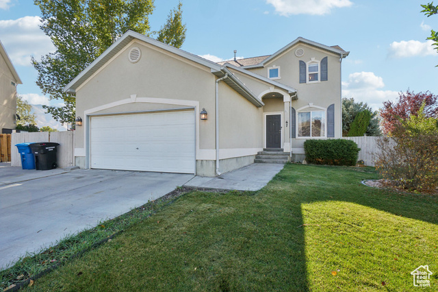 View of front of home with a front lawn and a garage