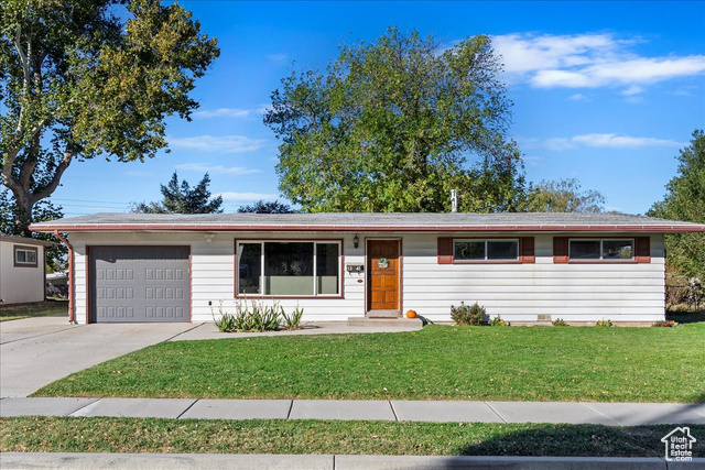 Ranch-style house with a front yard and a garage