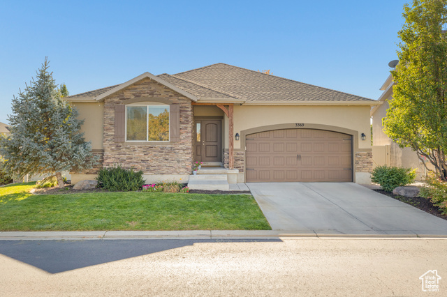 View of front of home with a front yard and a garage