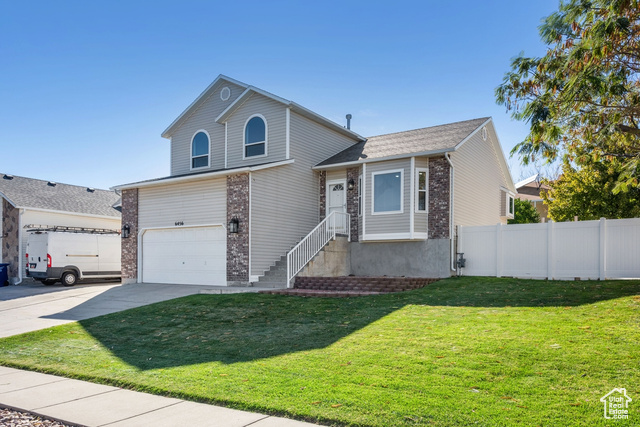 Front of property featuring a front yard and a garage