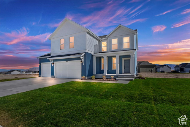 View of front facade with a 3-car garage and a lawn