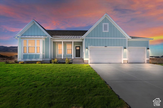 View of front of property with a lawn and a 3-car garage