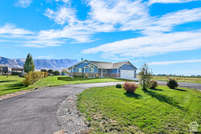 Ranch-style home with a mountain view and a front lawn