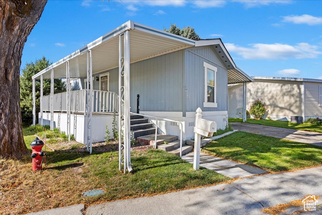 View of front of property featuring covered porch and a front lawn