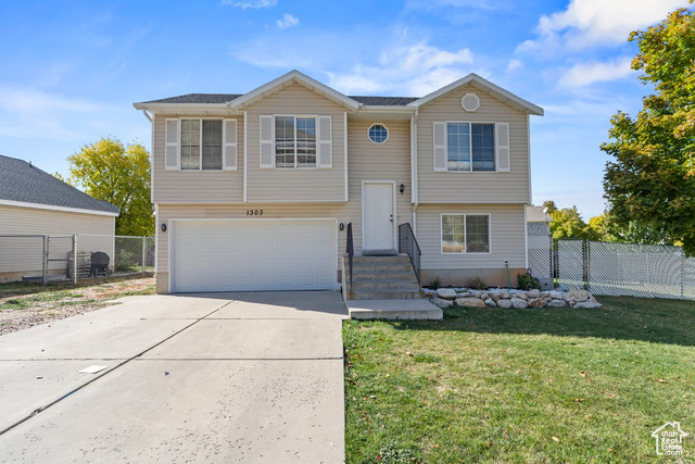 Raised ranch with a garage and a front yard