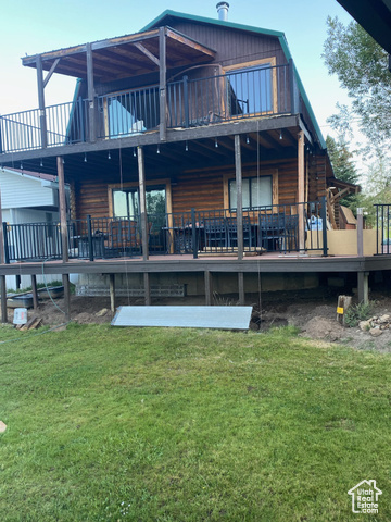 Rear view of property featuring a deck and a lawn