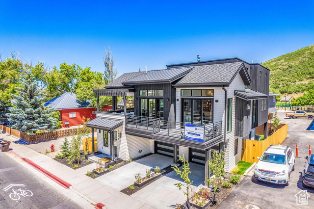 View of front of house featuring a garage and a balcony