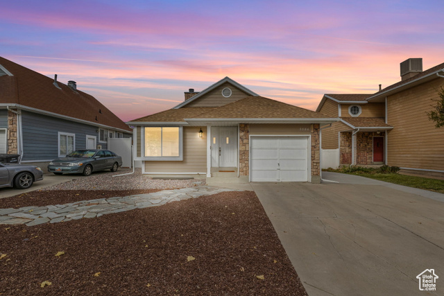 View of front of property featuring central AC and a garage