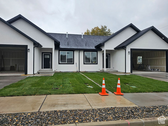 Ranch-style home featuring a front lawn and a garage