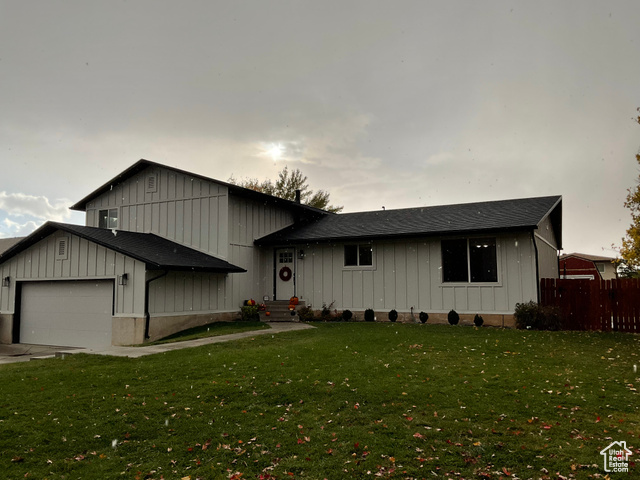 View of front facade with a front lawn and a garage