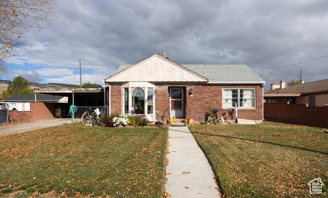 Bungalow with a front yard and a carport