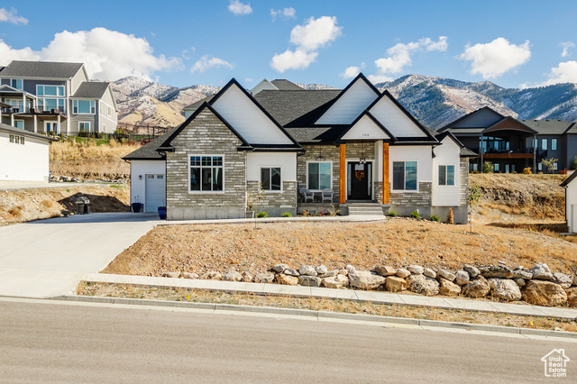 View of front of house with a mountain view and a garage