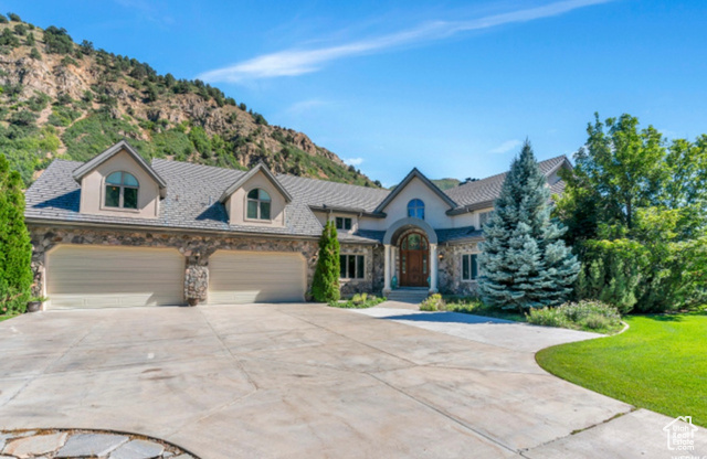 French country inspired facade with a garage and a mountain view