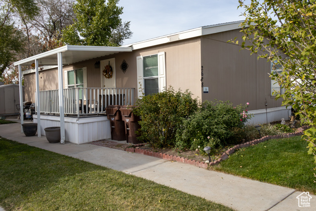 Manufactured / mobile home with a front yard and covered porch