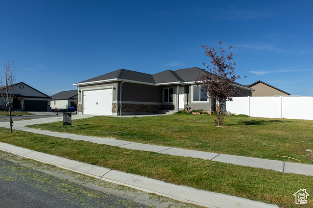 View of front of house with a front yard and a garage