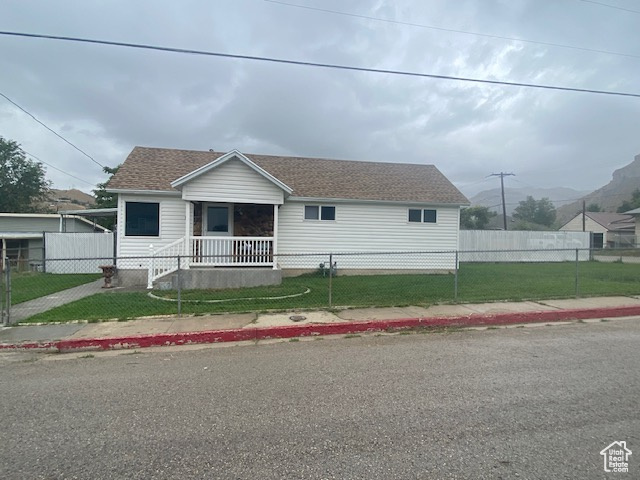 View of front of property featuring a porch and a front lawn