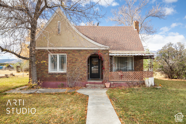 View of front of property featuring a porch and a front yard