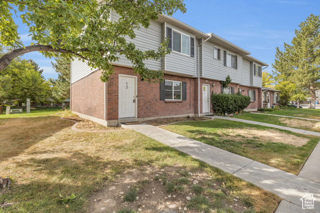 Townhome / multi-family property featuring a front lawn